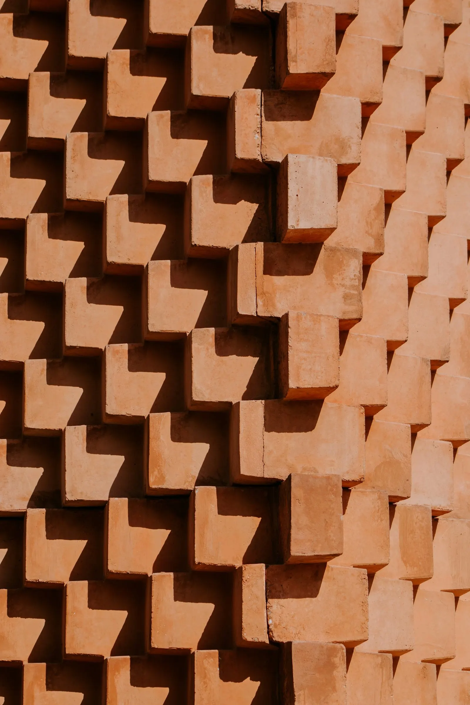 Brickwork laid in a stepped relief pattern catching the light